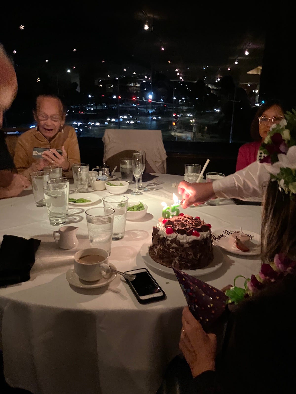 Dream cake with birthday candles, 65, being lit.