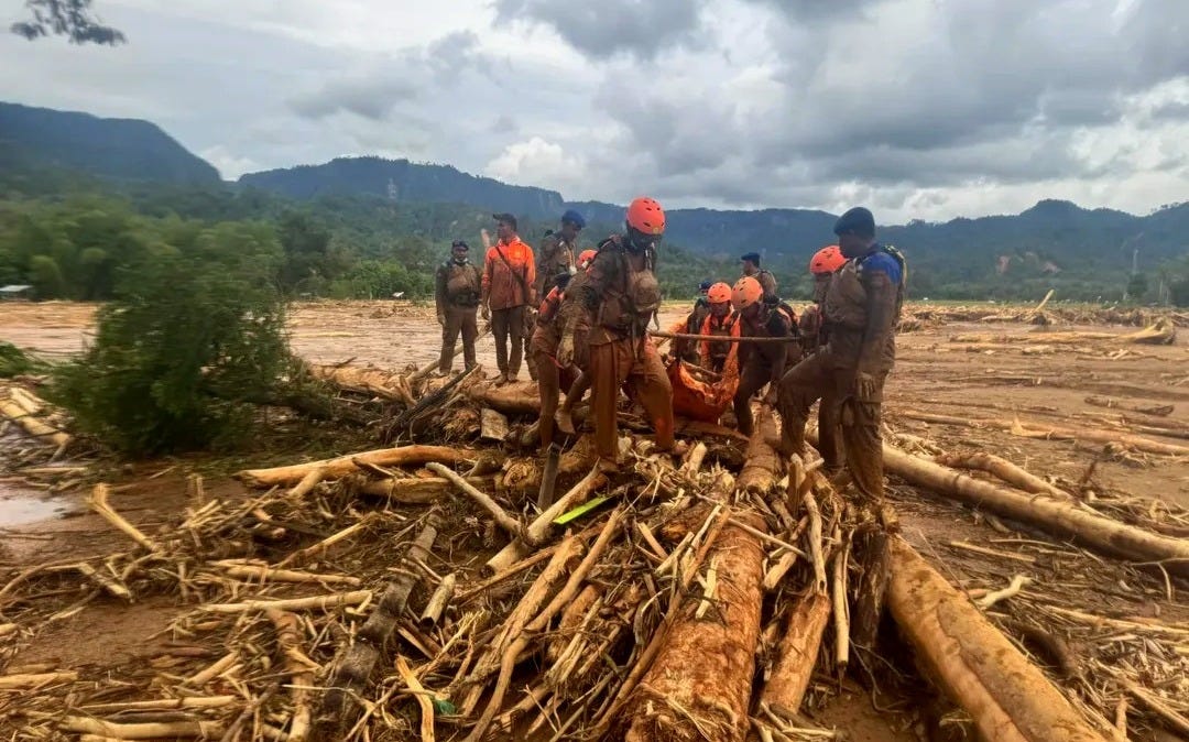 Indonesian search-and-rescue teams and local residents work together to pull a landslide victim from thick mud and debris during emergency operations in Sumatra. Indonesian search-and-rescue teams and local residents work together to pull a landslide victim from thick mud and debris during emergency operations in Sumatra.