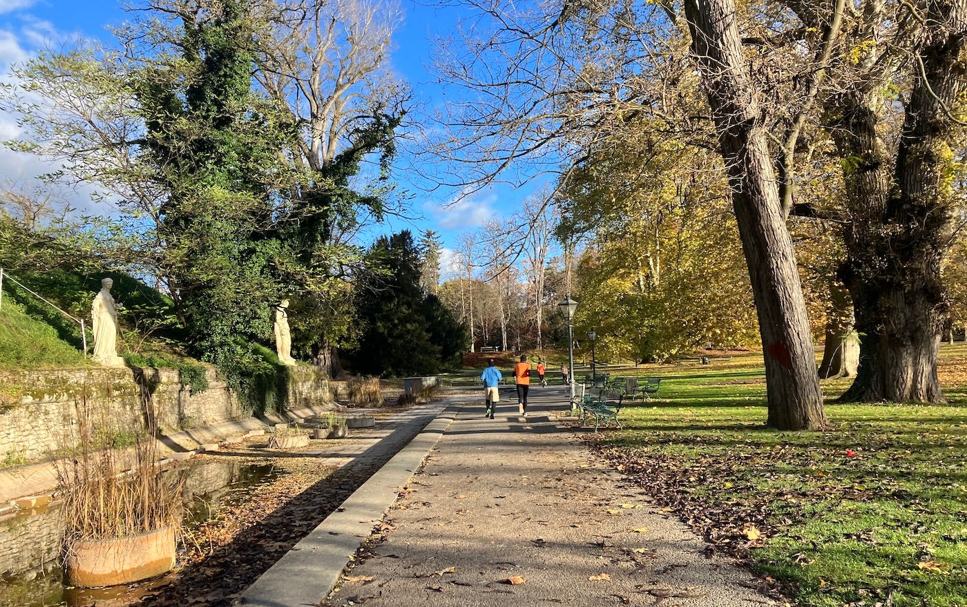 Running on a path next to a long pond, with statues looking over it