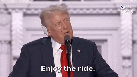 Donald Trump speaking at a rally, gesturing with his hand and saying “Enjoy the ride” with a smug expression.
