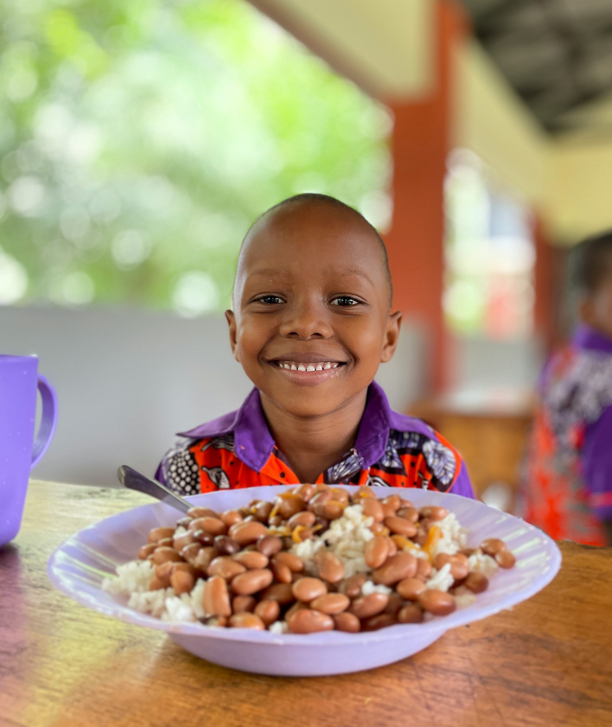 A boy sitting at a table with a plate of food