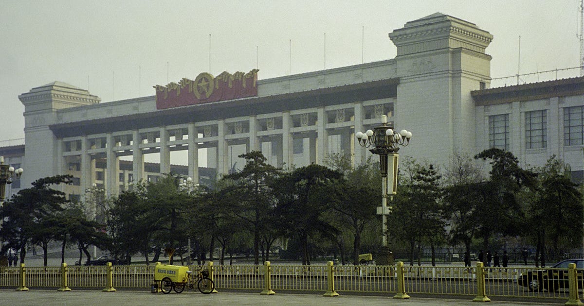 A hazy view of the Great Hall of the People in Beijing, framed by yellow barricades and a lone tricycle cart—symbolizing quiet Chinese observation amid global crisis. A hazy view of the Great Hall of the People in Beijing, framed by yellow barricades and a lone tricycle cart—symbolizing quiet Chinese observation amid global crisis.