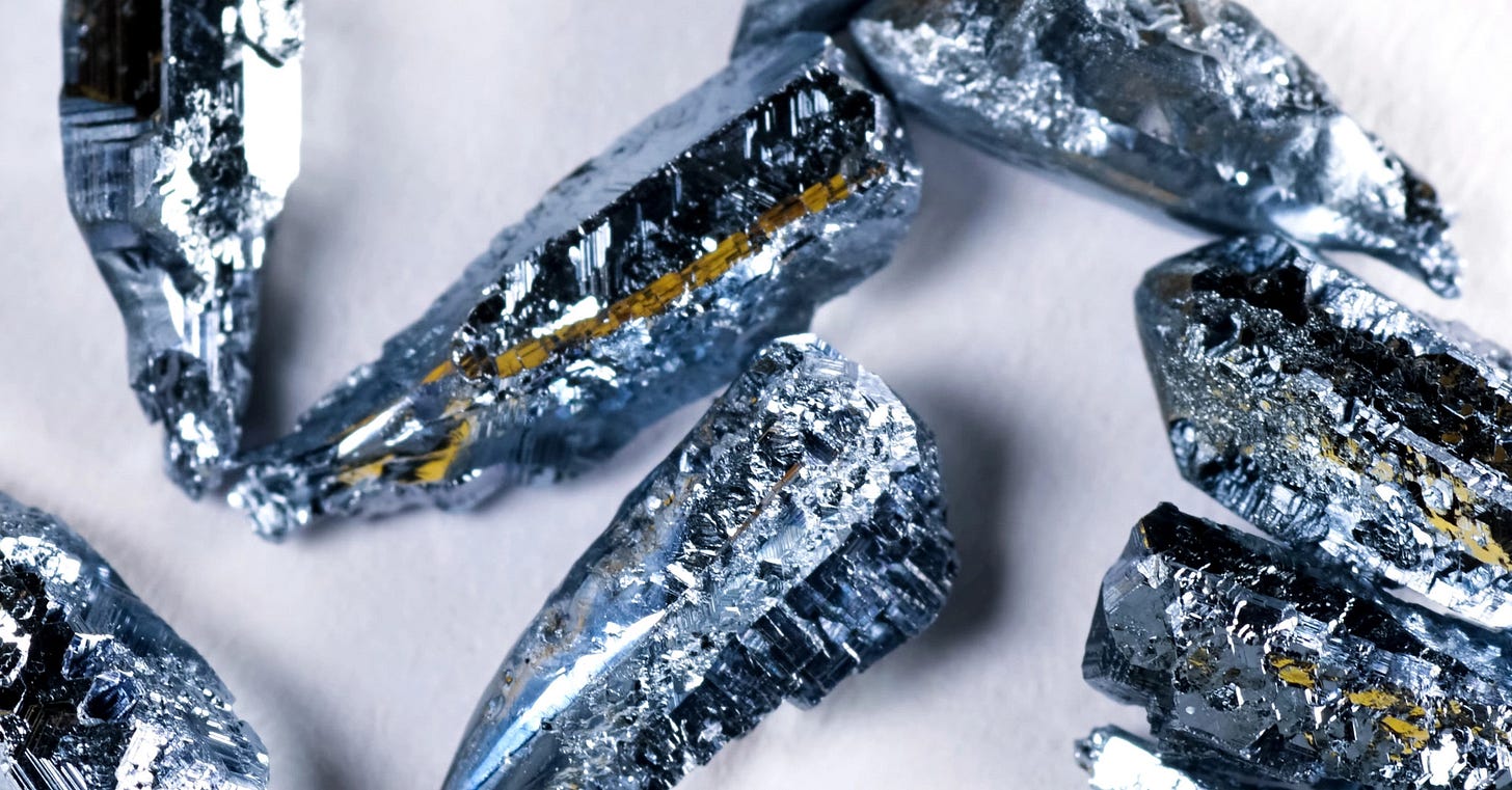 Bullet-shaped silvery nuggets of the metal, osmium, against a white background