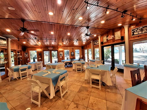 A sign showing River Oak Cottage Tea Room, along with a picture of a fireplace and bookcase and large tour with red Oriental rug. The last picture is white round tables and chairs with blue tablecloths and dinnerware.