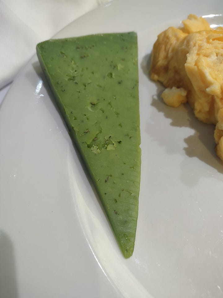 The photo gallery shows four pictures in a square. The top left picture is of a pita with a sour cream sauce and sausage meet. The top right image is of a sweets shop with Turkish and Bosnian sweets. The bottom left is of a wedge slice of green colored cheese and the bottom right is of a red colored wedge shaped slice of cheese.