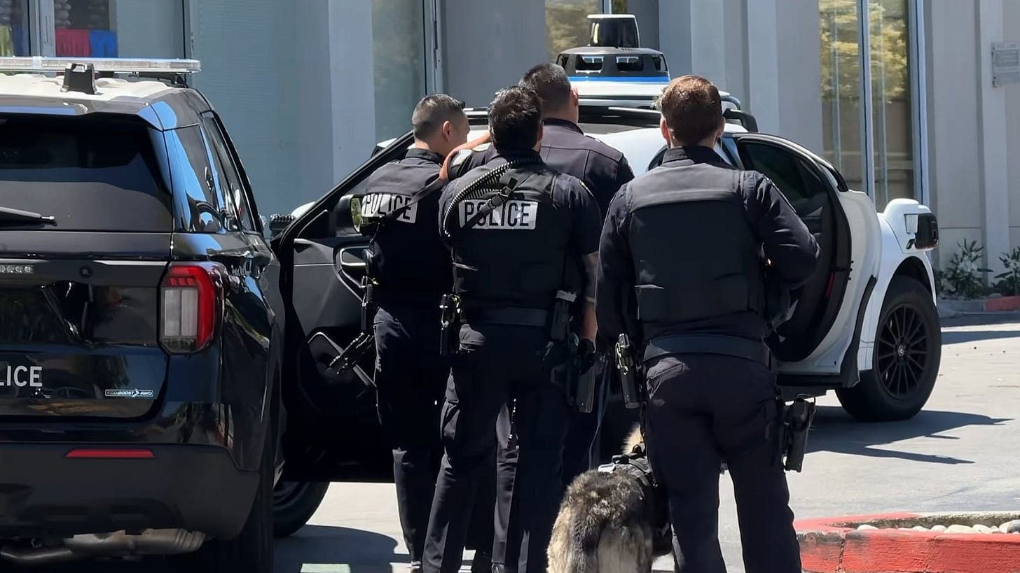 Police officers approach a robotaxi