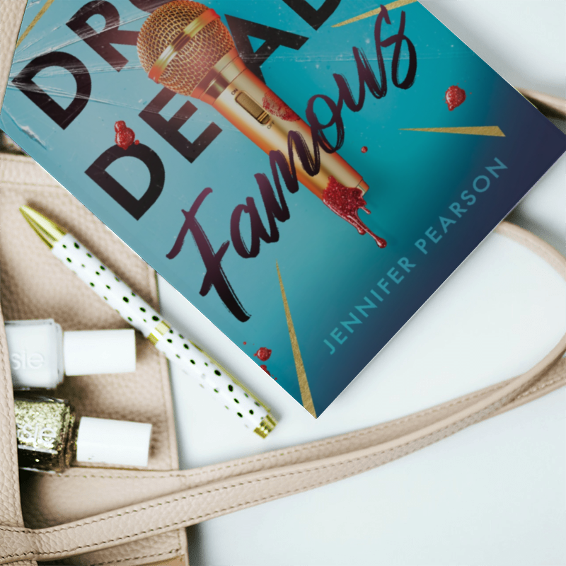 Book "Drop Dead Famous" next to pens and nail polish Book "Drop Dead Famous" next to pens and nail polish