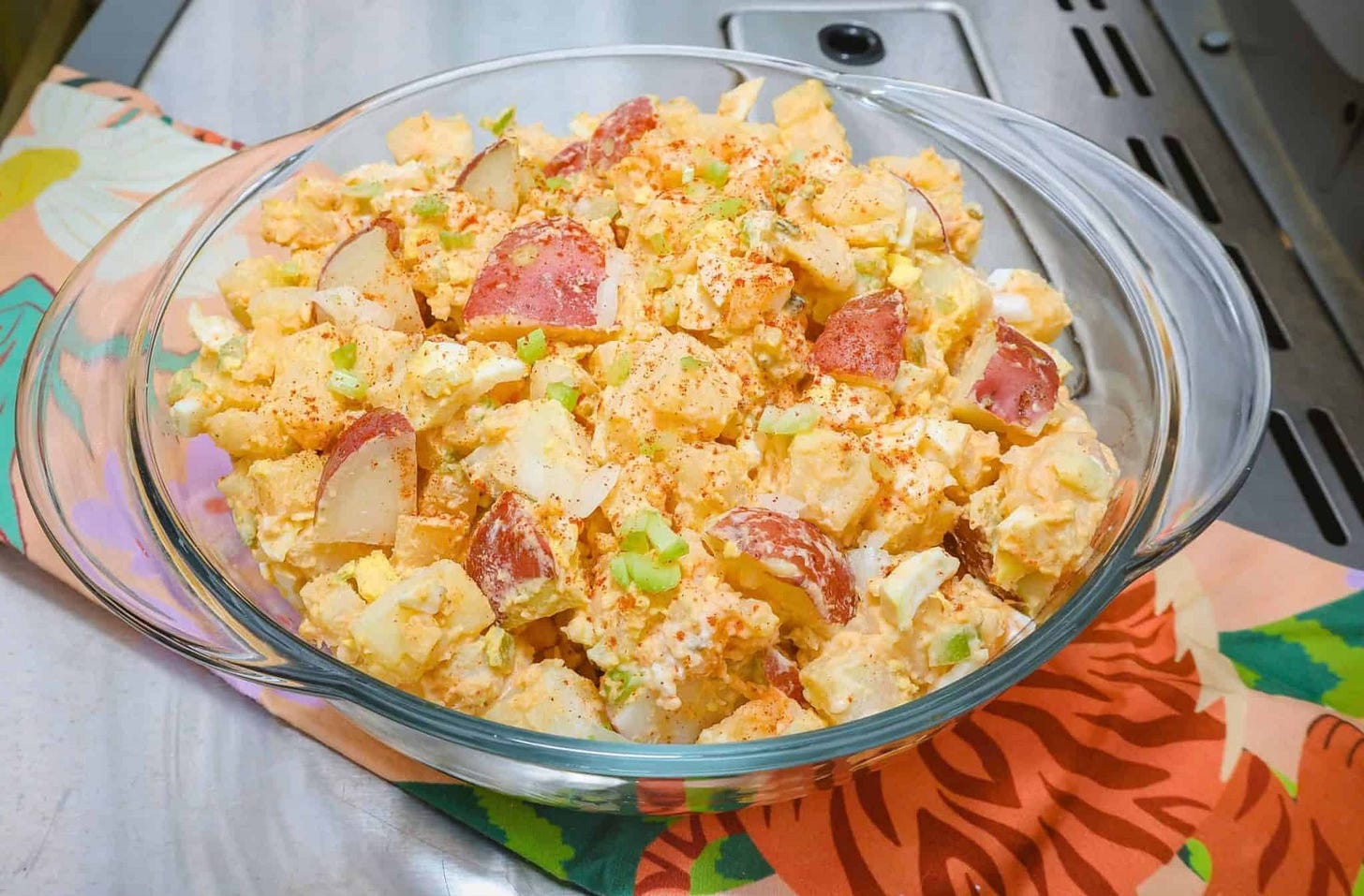 Black folks Southern potato salad sprinkled with paprika in a glass serving bowl, showing how paprika adds color and soul to a classic Juneteenth and cookout side dish from The Soul Food Pot®