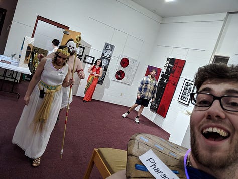 5 Pictures. 1) A group of people taking a selfie with a masked figure. 2) a group photo of people in alien costumes holding grocery bags. 3) Folks in pulpy "ancient egypt" costumes with a mummy chasing them. 4) a group of people in agressively christmasy outfits around a tree. 5) Black and white photo of a group dressed as mobsters.