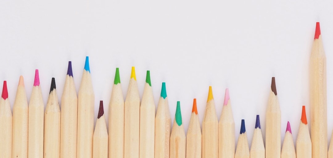 colored pencil lined up on top of white surface colored pencil lined up on top of white surface