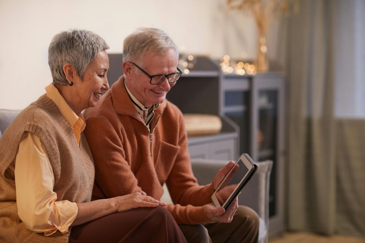 old couple smiling and looking at an ipad
