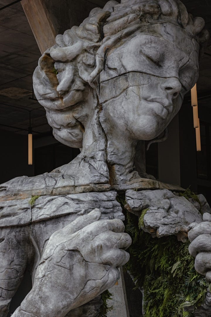 A very damaged, cracked statue of a woman