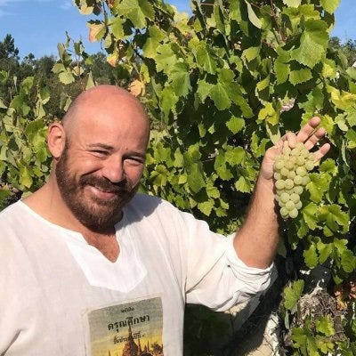 Photo of Alastair Leithead holding a bunch of grapes