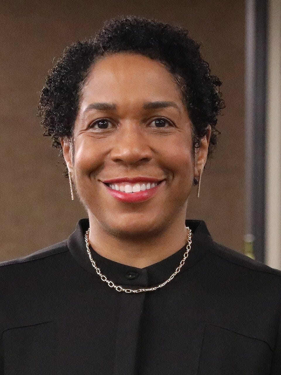 picture of Juliana Stratton; Black woman with short hair, black shirt, necklace, dangly earrings, smiling picture of Juliana Stratton; Black woman with short hair, black shirt, necklace, dangly earrings, smiling