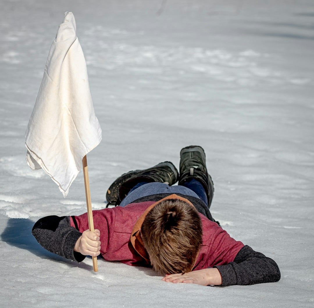 woman in black jacket lying on white snow