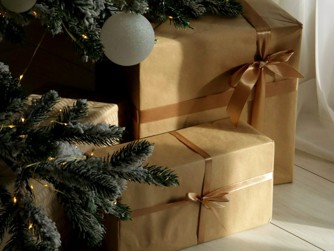 Christmas tree with gifts wrapped in brown paper.