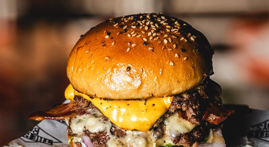A burger with cheese and beef on it