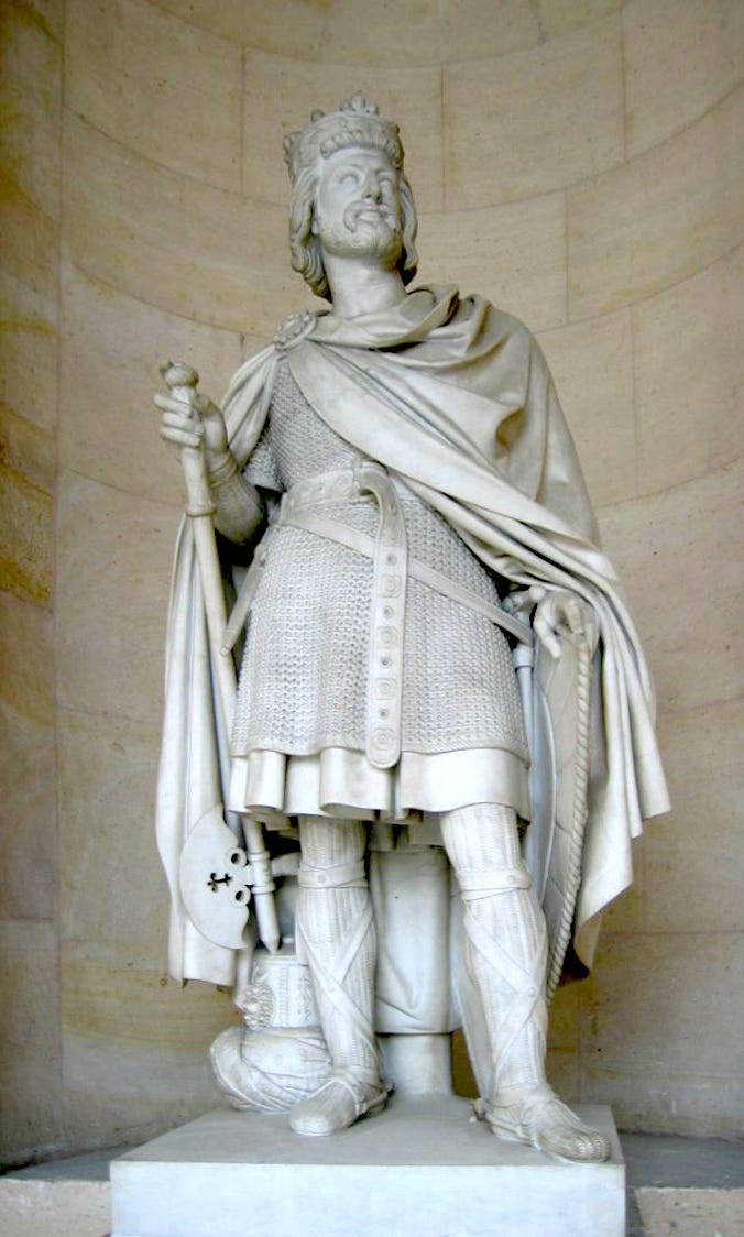 Statue of a man wearing a crown and chain mail and holding a battle-axe.