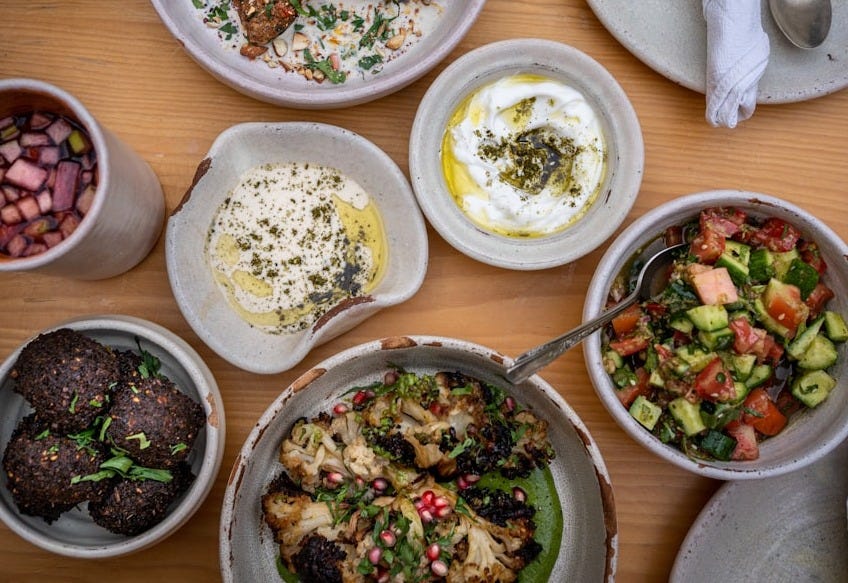 a wooden table topped with bowls of food