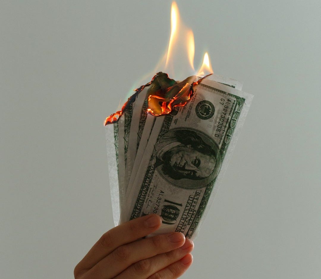 time lapse photography of several burning US dollar banknotes