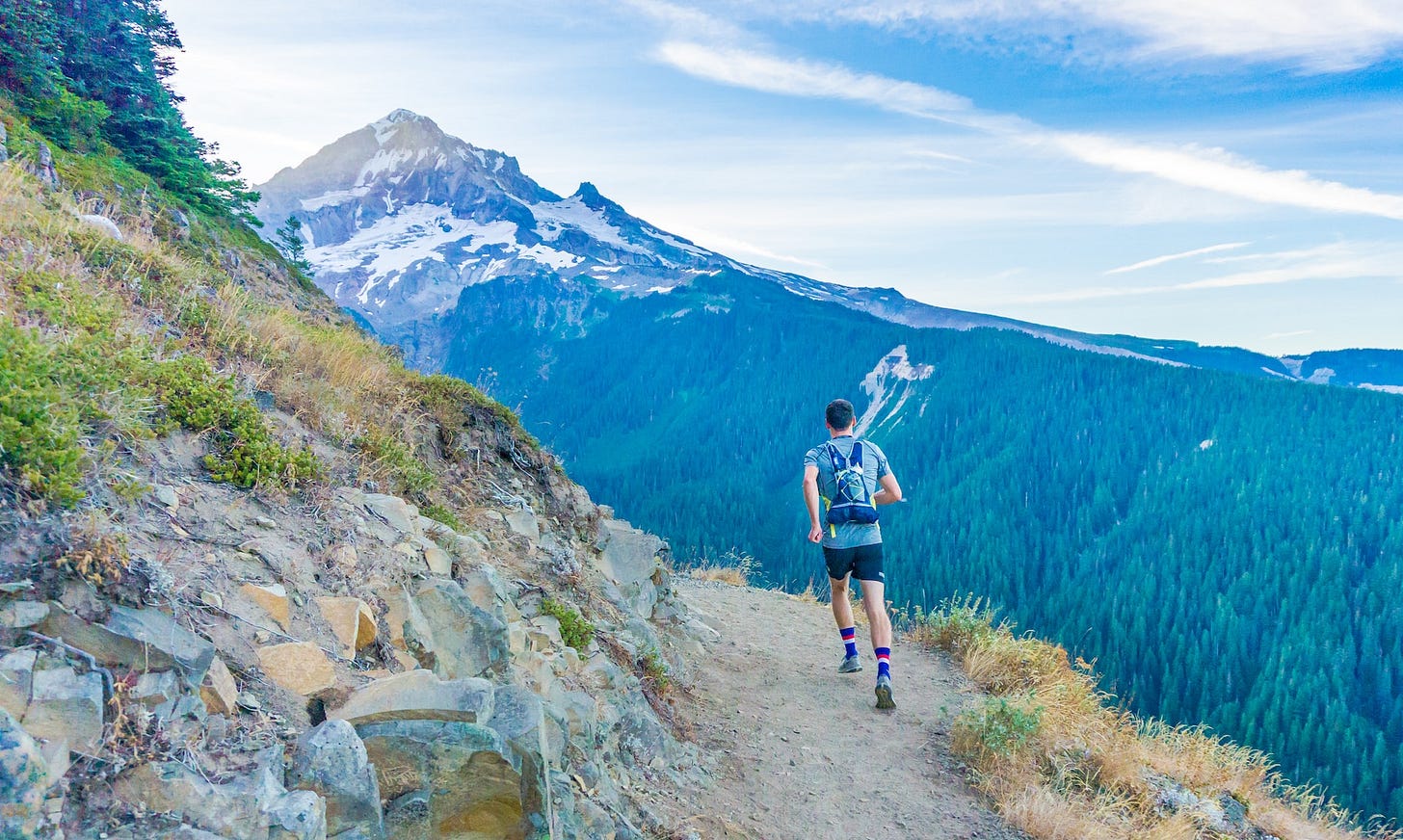 Image of a runner on a trail in the mountains.