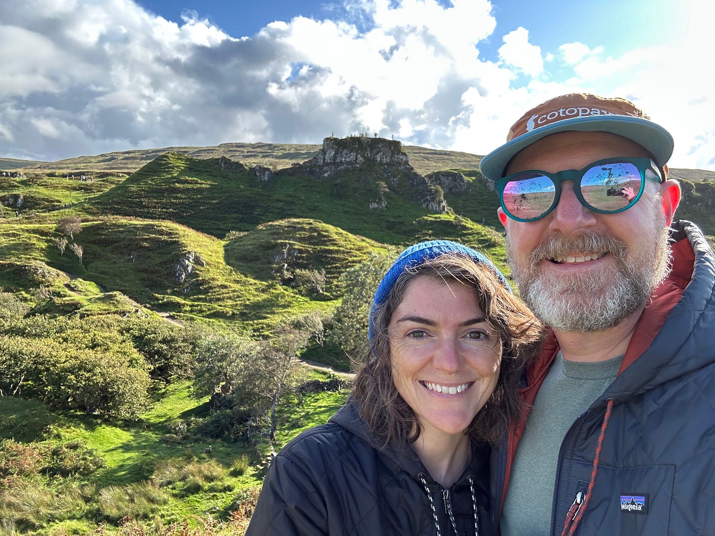 Green hilly background with my husband and I smiling in the foreground