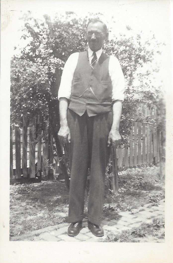 1920s-era man in his Sunday Best clothes standing in his backyard 1920s-era man in his Sunday Best clothes standing in his backyard