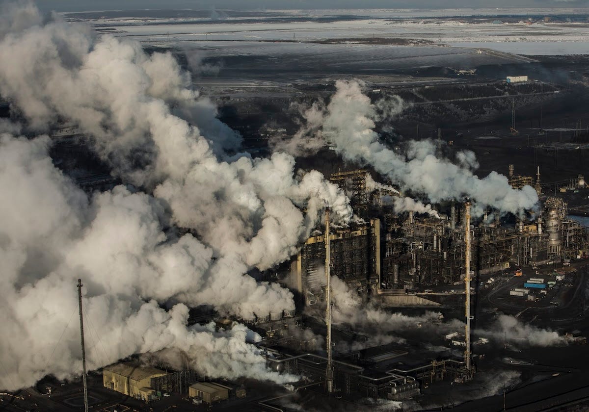 Overhead view of a sprawling industrial site with clouds rising from several smokestacks Overhead view of a sprawling industrial site with clouds rising from several smokestacks