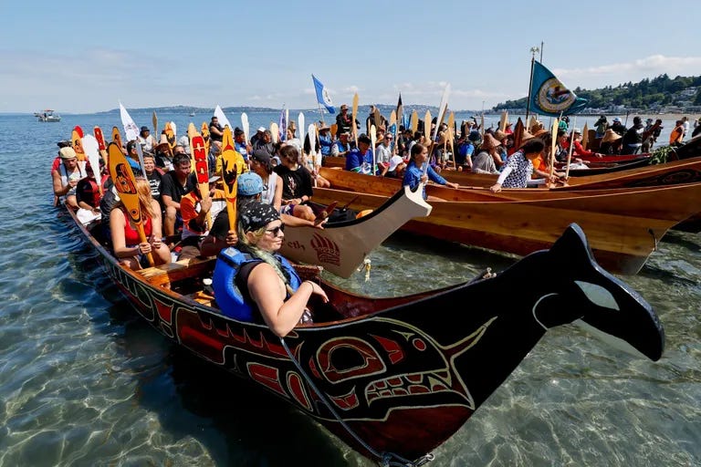 Canoe families wait to ask permission to come ashore at Alki Beach on the final leg of the 2023 canoe journey Sunday morning. (Jennifer Buchanan / The Seattle Times)