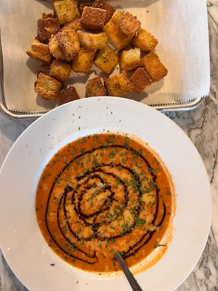 tomato bisque with balsomic drizzle and a plate of croutons