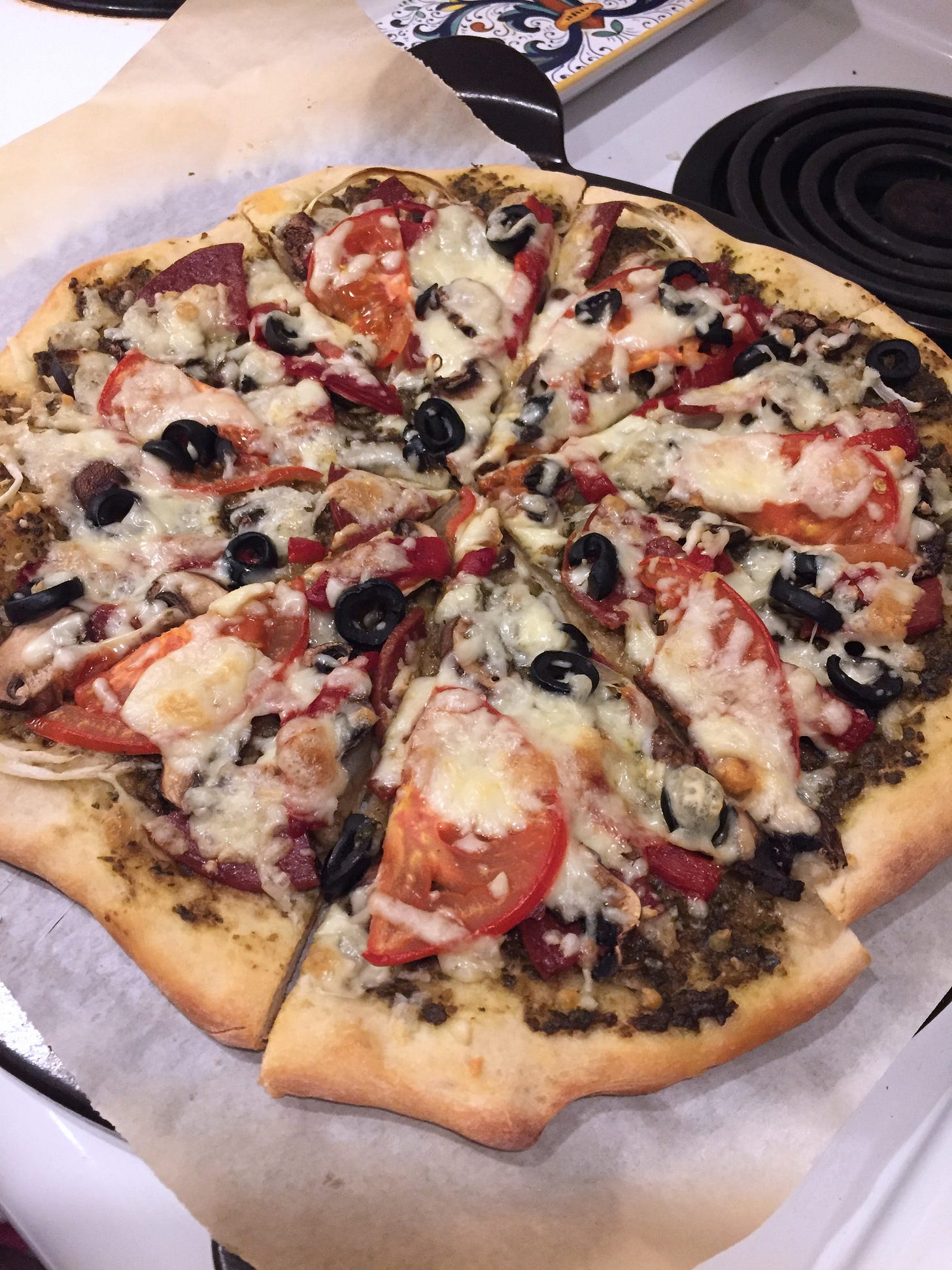 the pizza described below sits on a piece of parchment paper on top of a pizza stone. 