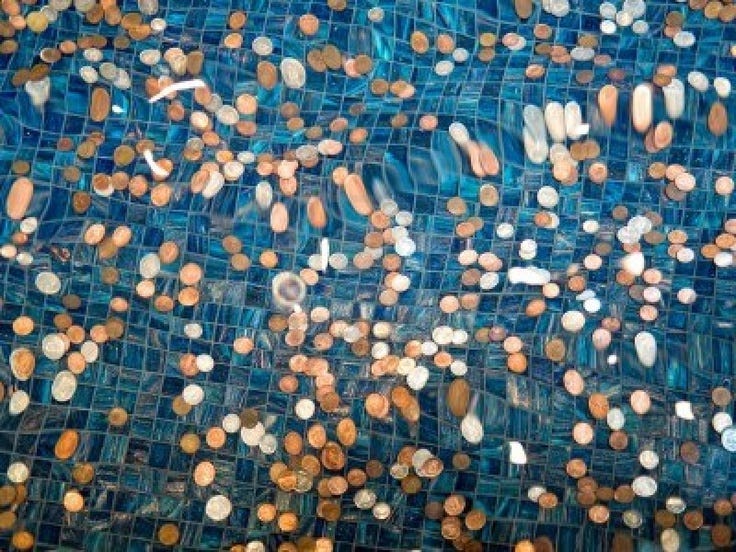 This may contain: an abstract photograph of blue and gold circles on glass tiles with water droplets in the middle