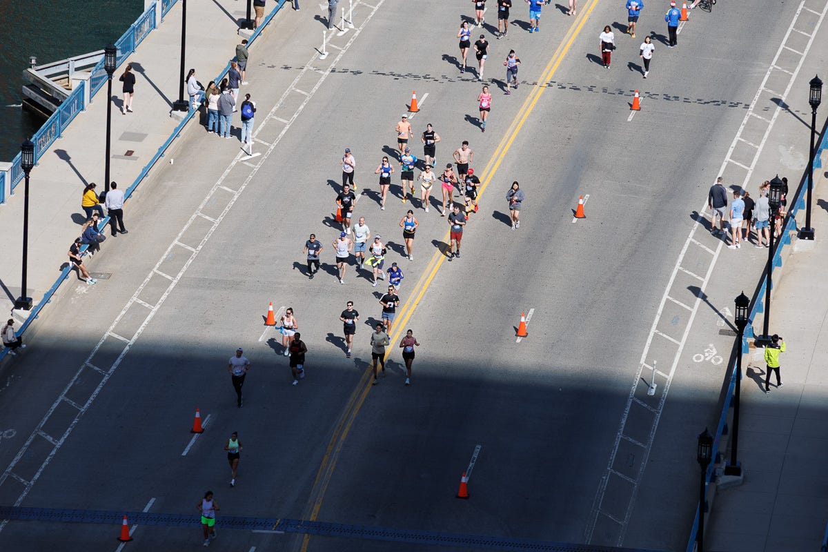Overhead view of runners crossing Seaport Boulevard during an organized event, seen from high above. Overhead view of runners crossing Seaport Boulevard during an organized event, seen from high above.