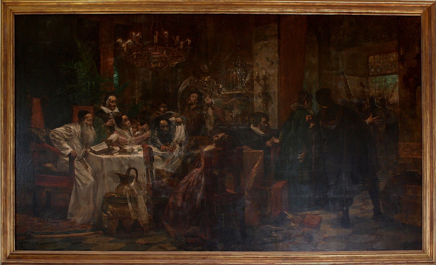 A dark, candlelit dining room: a family around a white tablecloth turns toward armed men coming in from the right, a woman collapses in her chair, and an old man in white sits at the head of the table with a book. A dark, candlelit dining room: a family around a white tablecloth turns toward armed men coming in from the right, a woman collapses in her chair, and an old man in white sits at the head of the table with a book.
