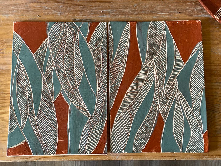 ceramic pieces decorated with a nature abstract design using slips and sgraffito: two platters, two flat panels and a vase