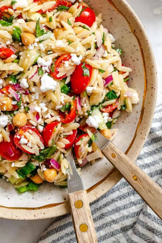 Summer Orzo Pasta Salad in a bowl with two spoons Summer Orzo Pasta Salad in a bowl with two spoons