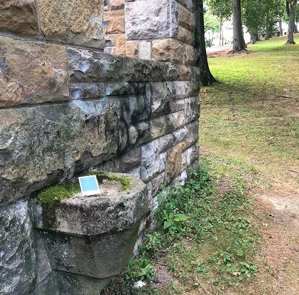 The old stone park building and trees in background.