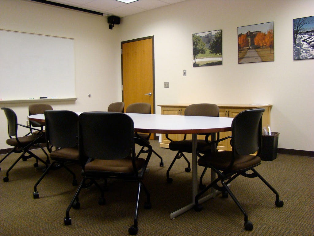 Meeting table in conference room and whiteboard Meeting table in conference room and whiteboard