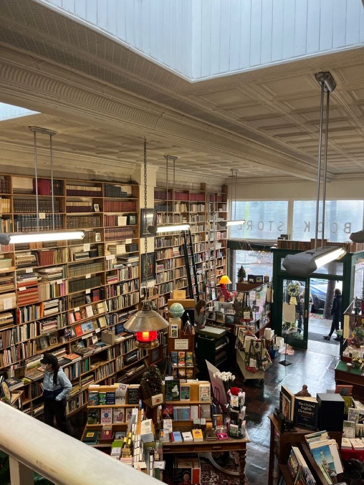 This may contain: a large room filled with lots of books on top of shelves next to a staircase