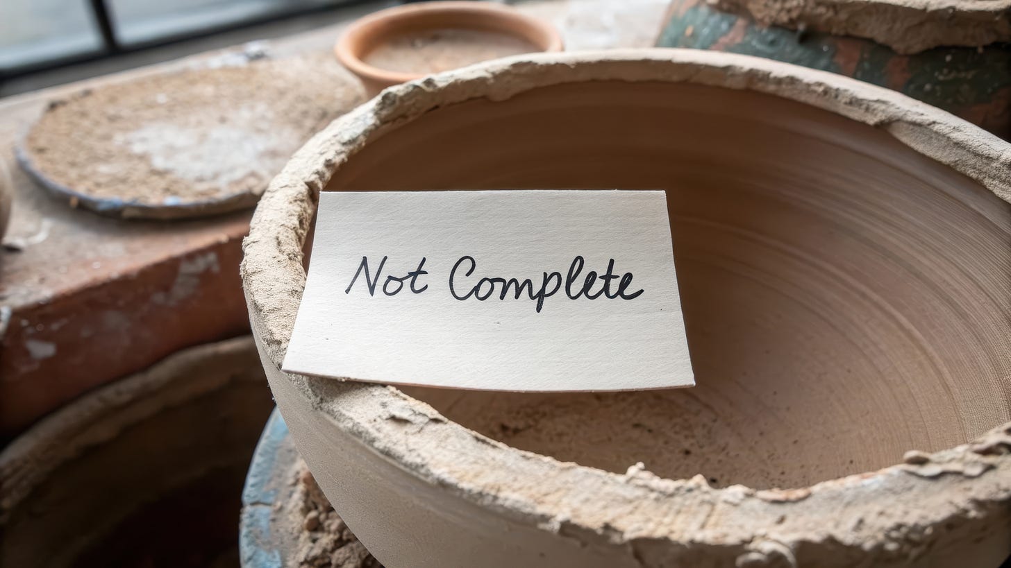 An unglazed clay pot with a handwritten note reading “Not Complete,” symbolizing patience, process, and the wisdom of waiting before the fire. An unglazed clay pot with a handwritten note reading “Not Complete,” symbolizing patience, process, and the wisdom of waiting before the fire.