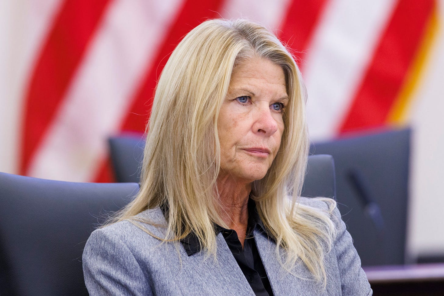 Florida State Senator Debbie Mayfield seated in a hearing room with an American flag in the background. Florida State Senator Debbie Mayfield seated in a hearing room with an American flag in the background.