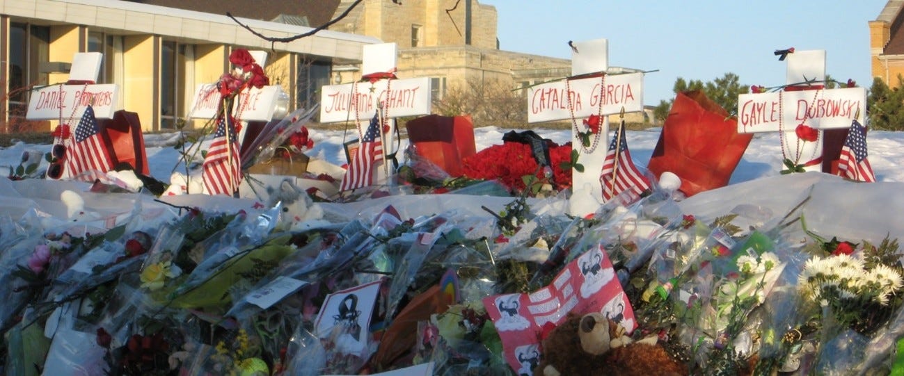A solemn memorial honoring the victims, surrounded by flowers and candles.