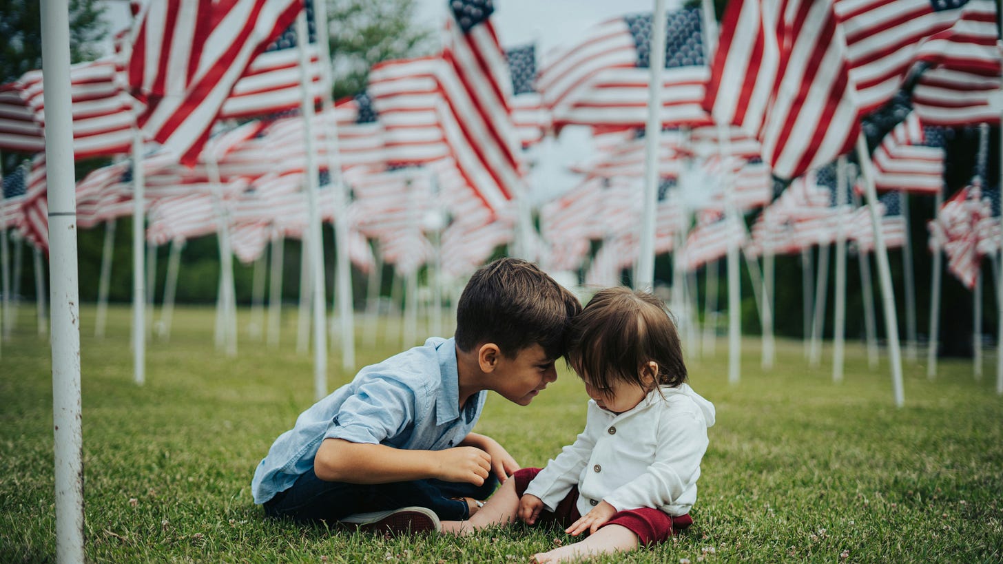 children sitting amongst American flags