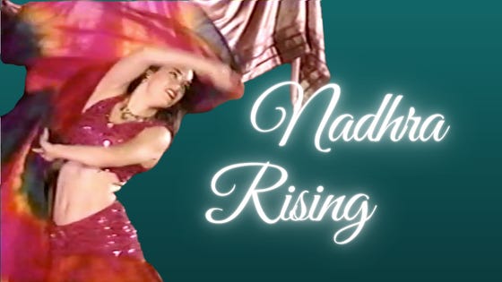 The author in a hot pink and fire-tone costume, wielding a pink and rainbow veil: Nadhra Rising. The author in a hot pink and fire-tone costume, wielding a pink and rainbow veil: Nadhra Rising.