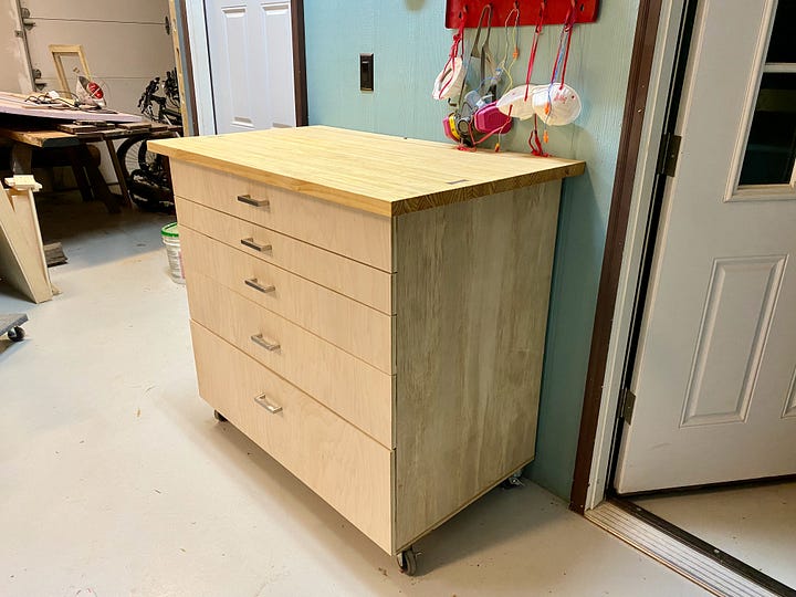 Heavy-duty caster wheels, laminated-pine top, walnut bow tie inlay, and full picture of a shop cabinet.