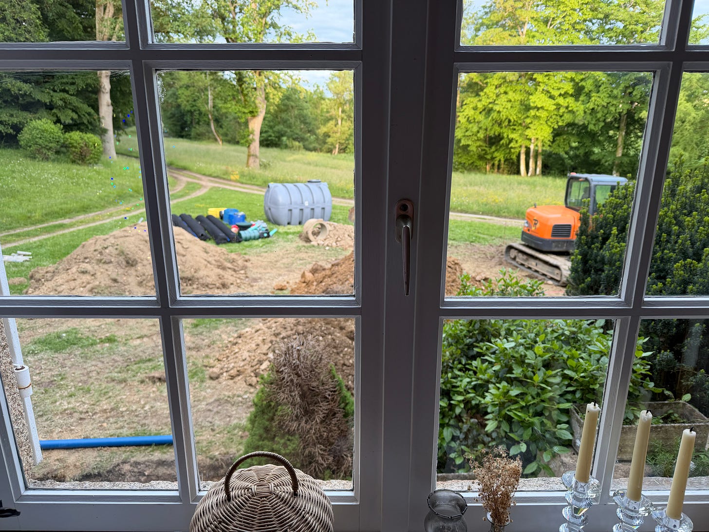 View of septic installation construction site from inside a French château window View of septic installation construction site from inside a French château window