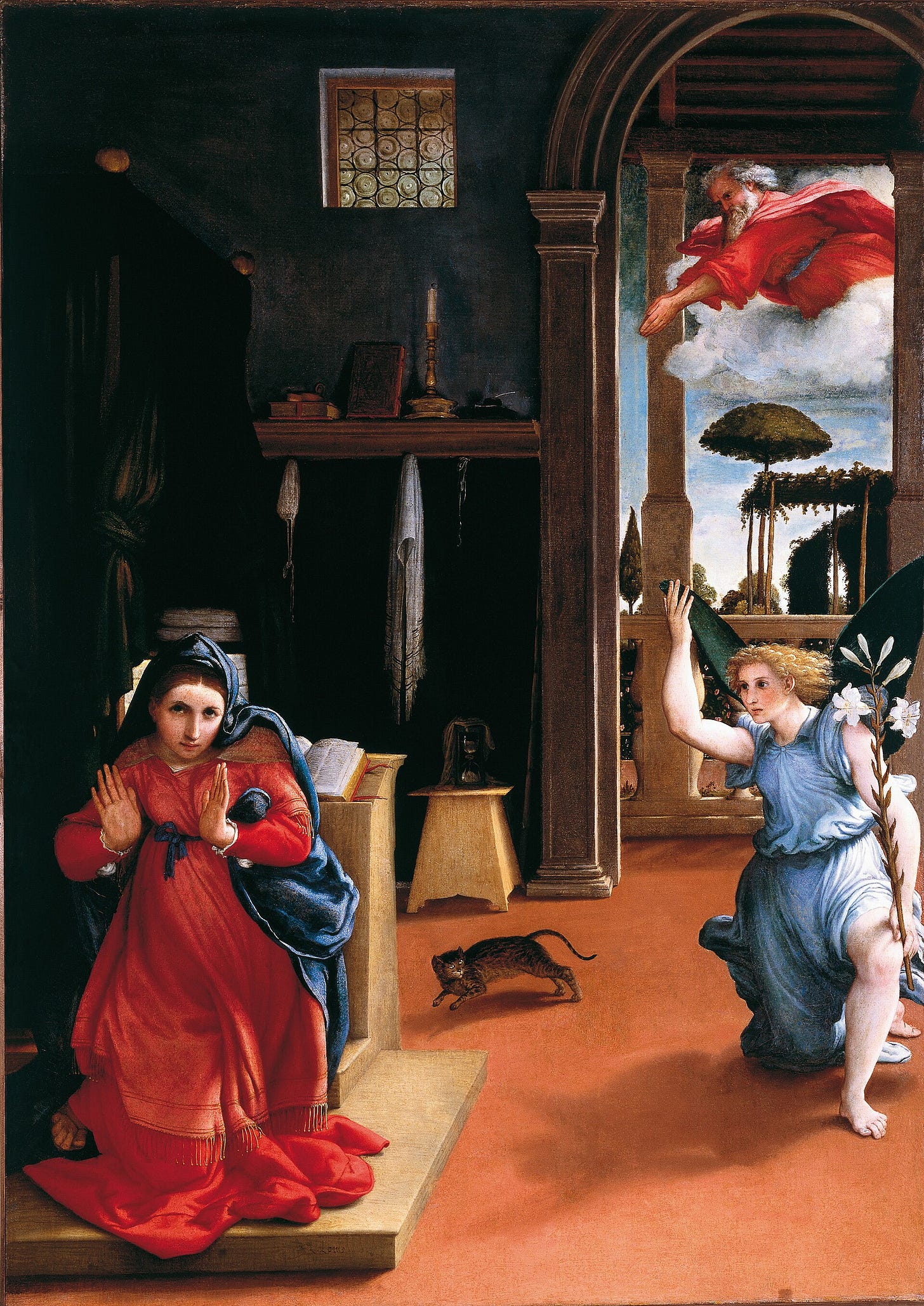 In a plain bedroom, a young woman in red and blue kneels at a prayer stool in the foreground and turns toward the viewer with both hands raised. Behind her, an angel holding a lily has just landed on the floor, God the Father plunges from a cloud in the doorway, and a tabby cat arches its back and runs across the room between them.