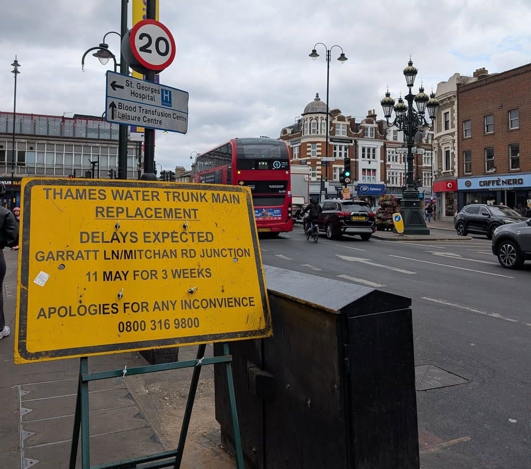 May be an image of street and text that says "20 .ต Blond Trangf THAMES WATER TRUNK TRUNKMAIN MAIN REPLACEMENT DELAYS EXPECTED GARRATT LN/MITCHAN RD JUNCTION 11 MAY FOR 3 WEEKS APOLÓGIES FOR ANY INCONVIENCE 0800 316 9800"