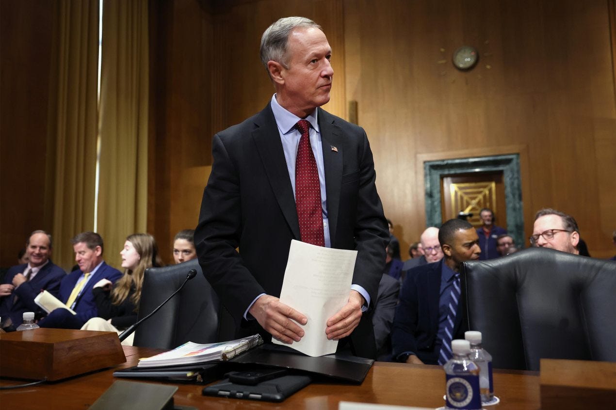 A photo of Martin O'Malley standing inside a Senate committee hearing room. A photo of Martin O'Malley standing inside a Senate committee hearing room.
