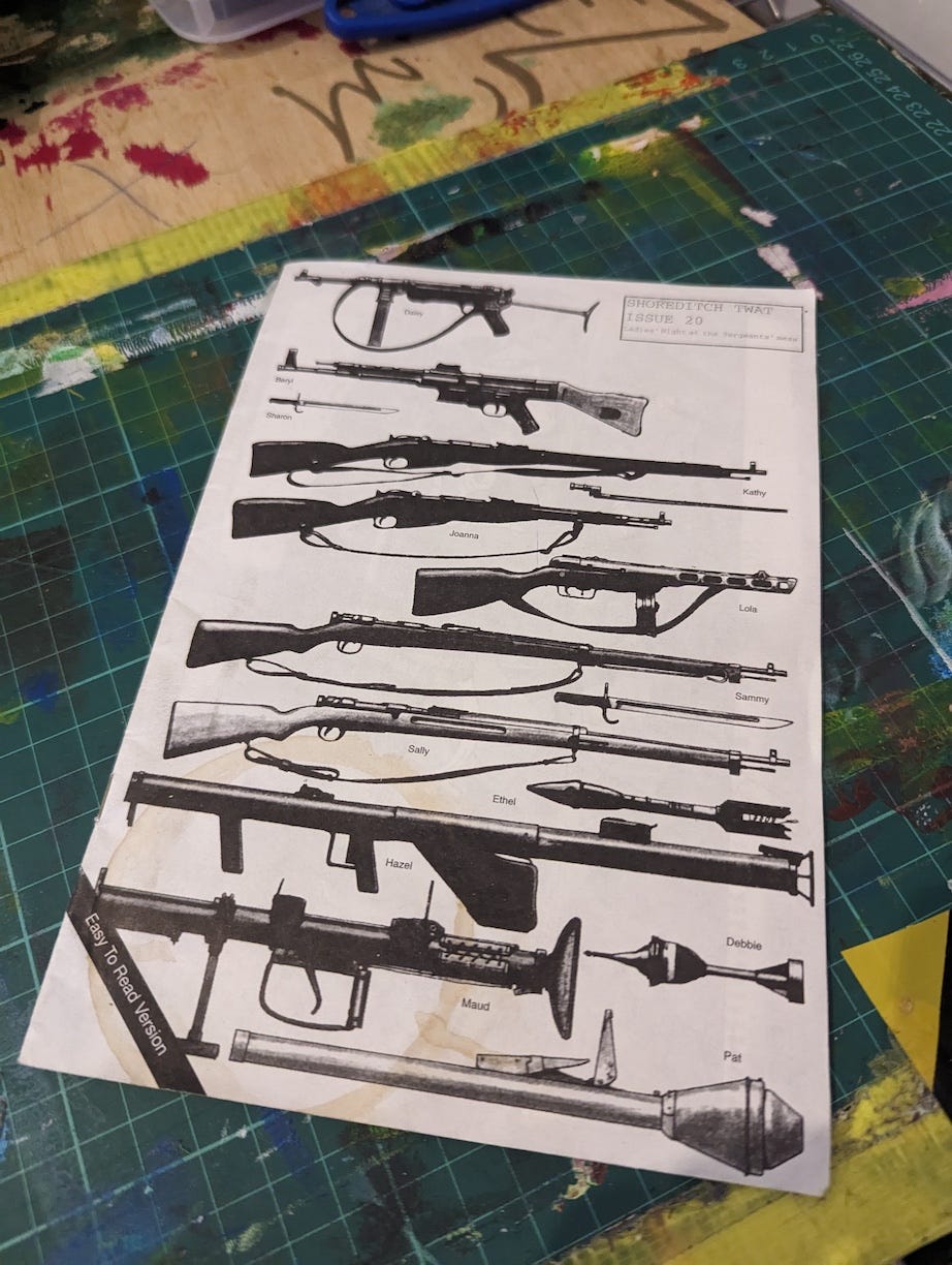 The image shows a page from a zine titled "Shoreditch Twat, Issue 20." The page features a series of illustrations of various firearms, each labeled with a person's name such as "Daisy," "Sharon," "Joanna," and "Hazel." The firearms are depicted in a simple, black-and-white style, with different types ranging from rifles to rocket launchers. In the bottom corner, the phrase "Easy To Read Version" is printed. The zine appears to play on the juxtaposition of mundane or feminine names with military weapons, possibly satirizing urban culture or trends in a humorous or provocative manner. The image shows a page from a zine titled "Shoreditch Twat, Issue 20." The page features a series of illustrations of various firearms, each labeled with a person's name such as "Daisy," "Sharon," "Joanna," and "Hazel." The firearms are depicted in a simple, black-and-white style, with different types ranging from rifles to rocket launchers. In the bottom corner, the phrase "Easy To Read Version" is printed. The zine appears to play on the juxtaposition of mundane or feminine names with military weapons, possibly satirizing urban culture or trends in a humorous or provocative manner.